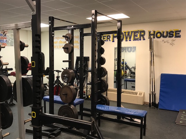 A gym with weights and equipment in a room.