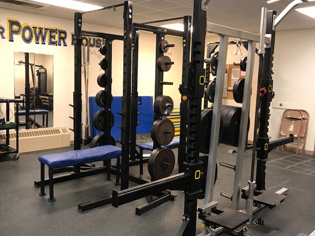 A well-equipped gym with weights and exercise equipment in a spacious room.