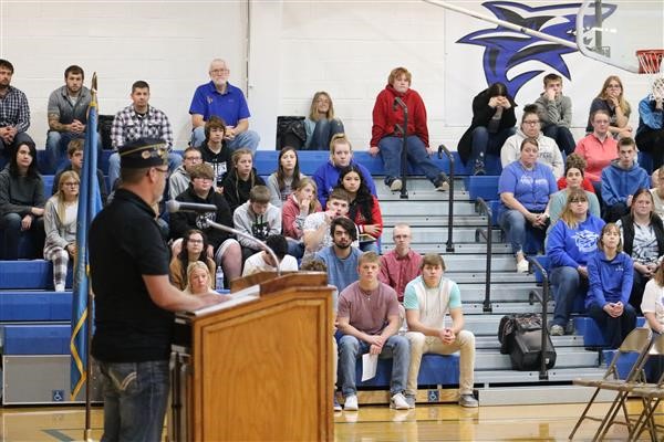 A man confidently addressing a large audience from a podium, capturing their attention and engagement.