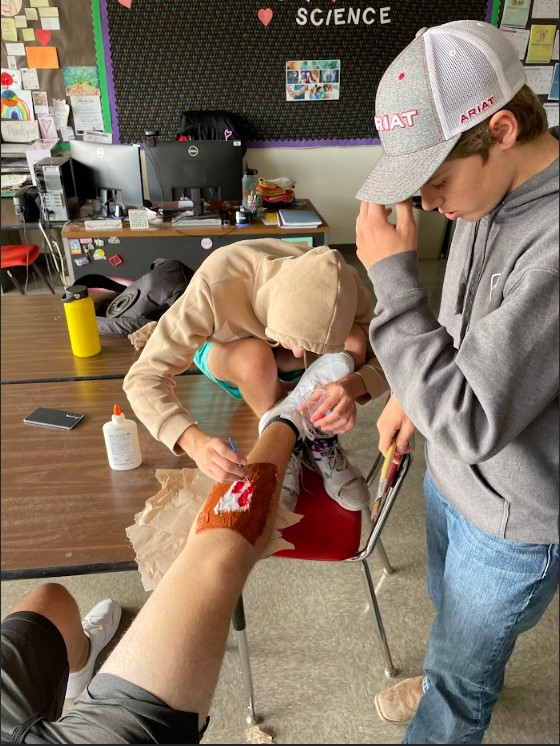 The First Aid class used moulage to make fake wounds and then practice different methods of controlling the "bleed" and checking patient vital signs.