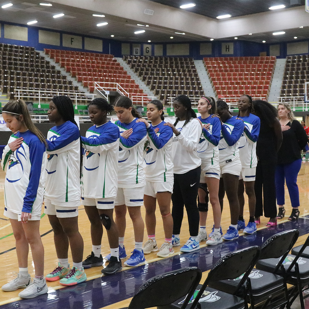 Basketball team lined up alongside court