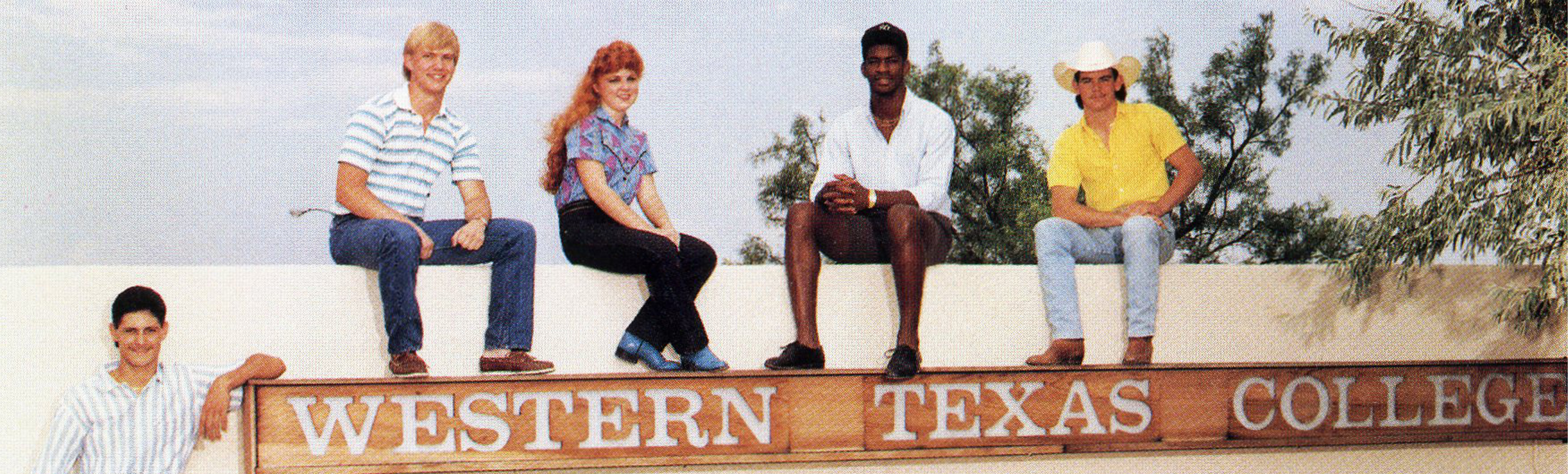 WTC students sitting on name sign