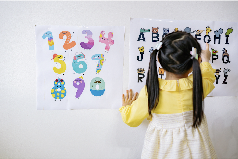Kid interacting with numbers and letters on the wall