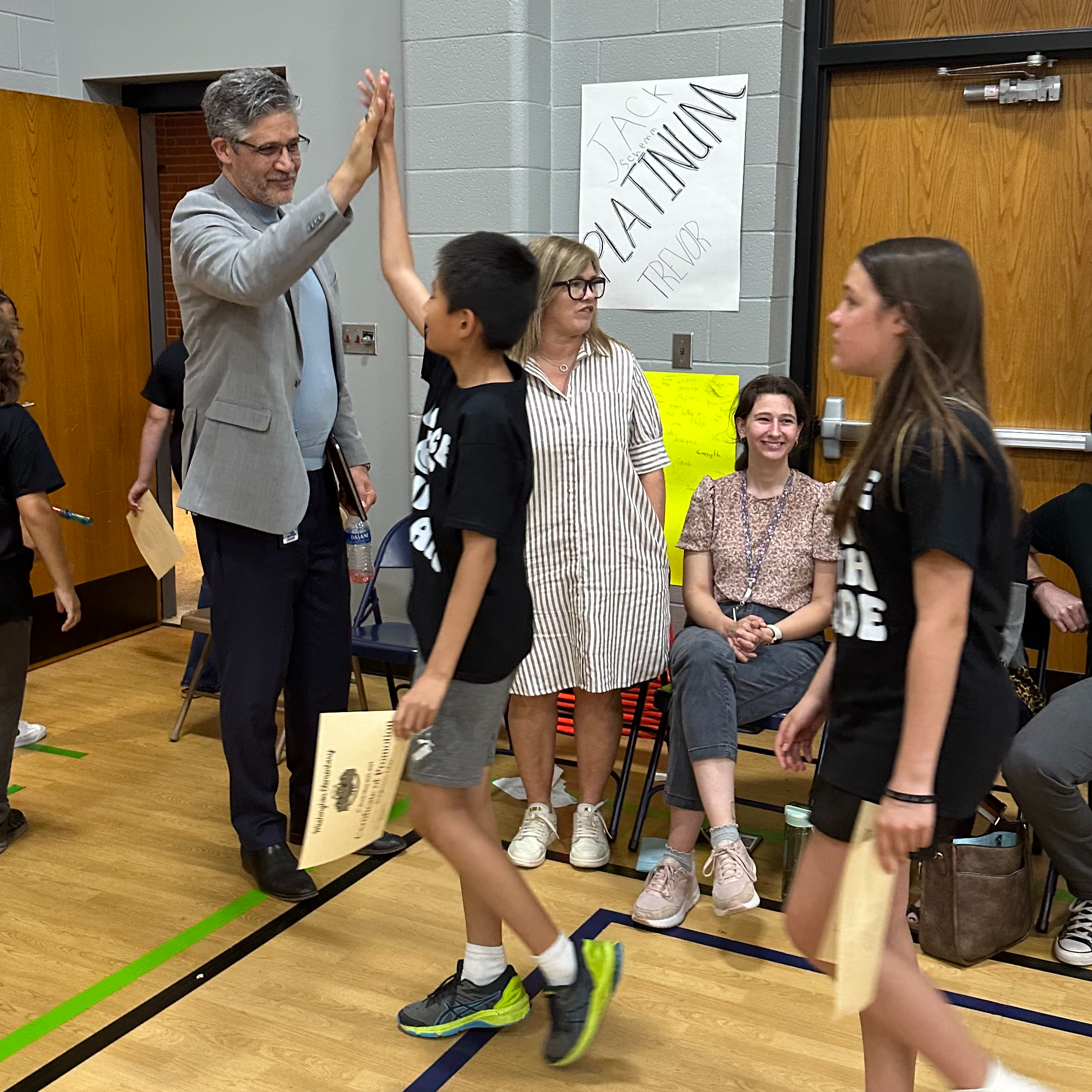 Dr. Nick Migliorino high fives students