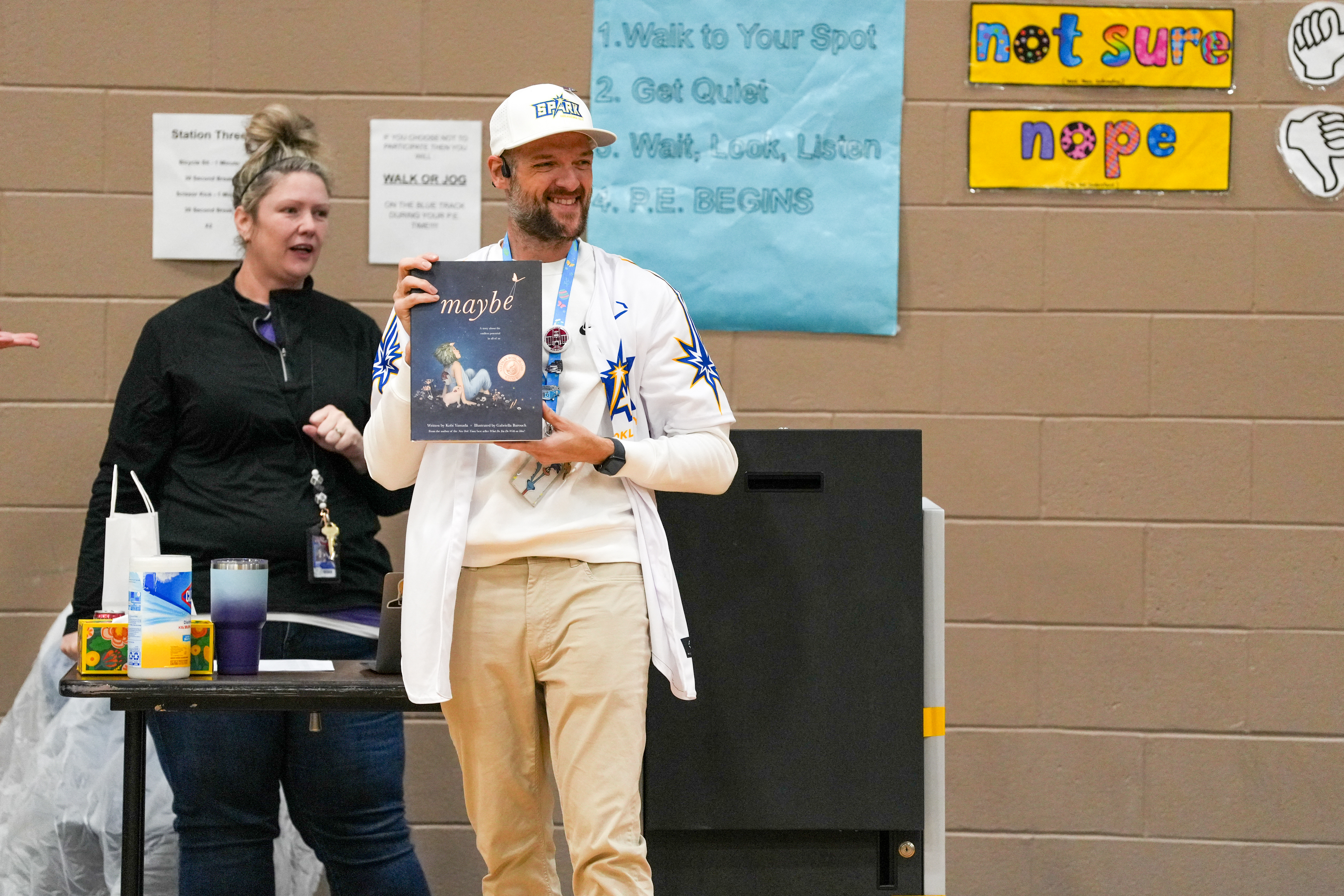 teacher holding book during assembly