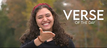 student smiling at the camera doing hand gestures