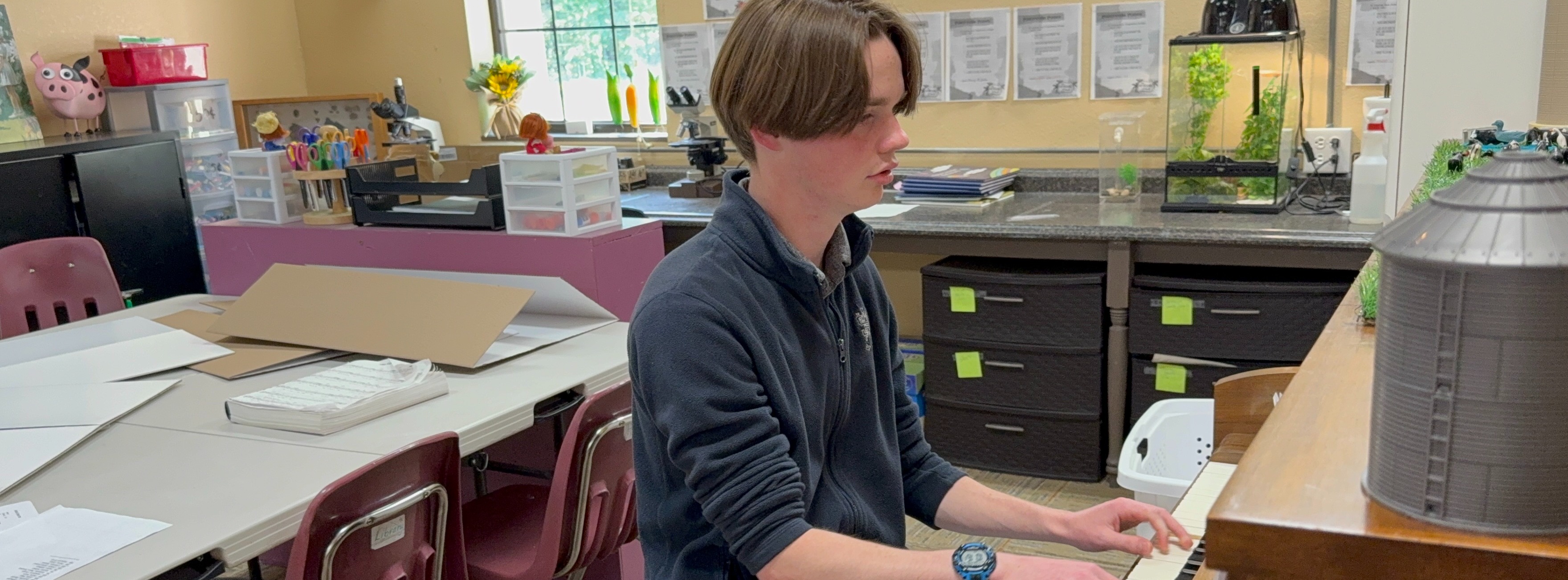 Young man playin piano in a classroom