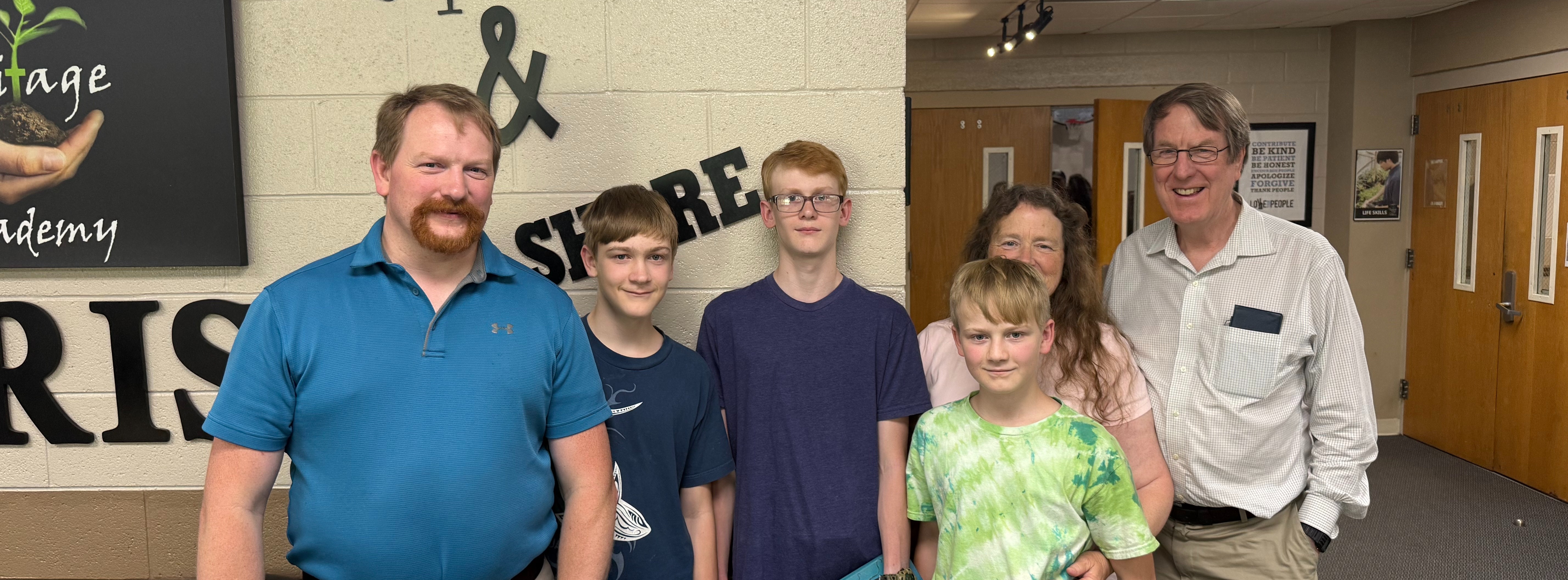 family posing together inside school building