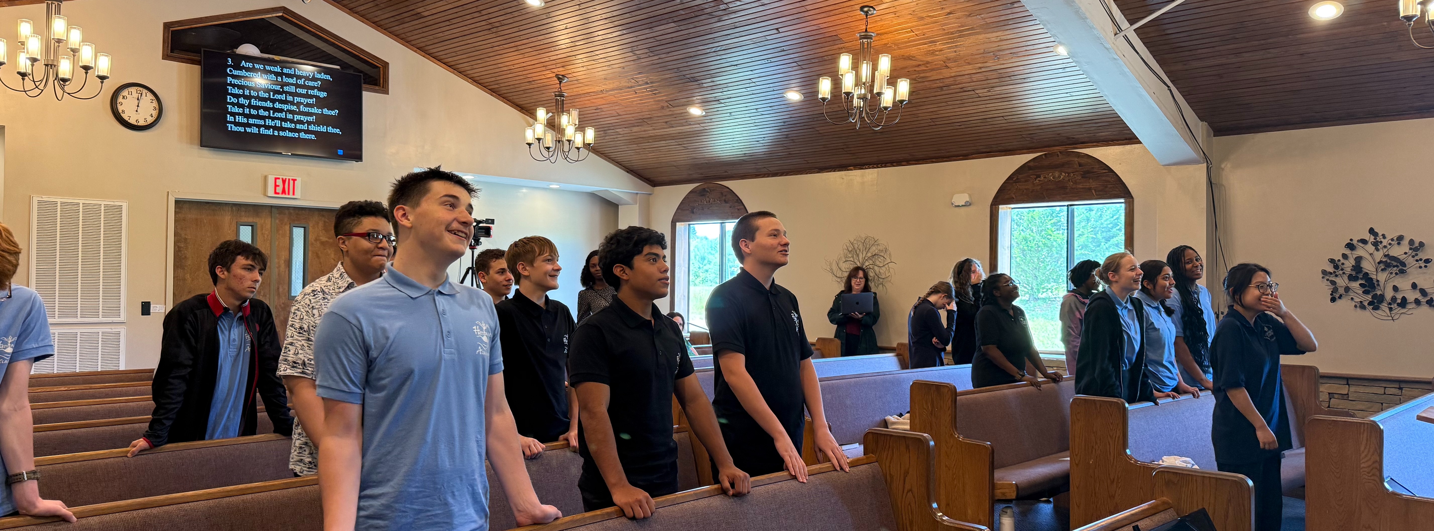 teen students in uniform in chapel looking forward smiling