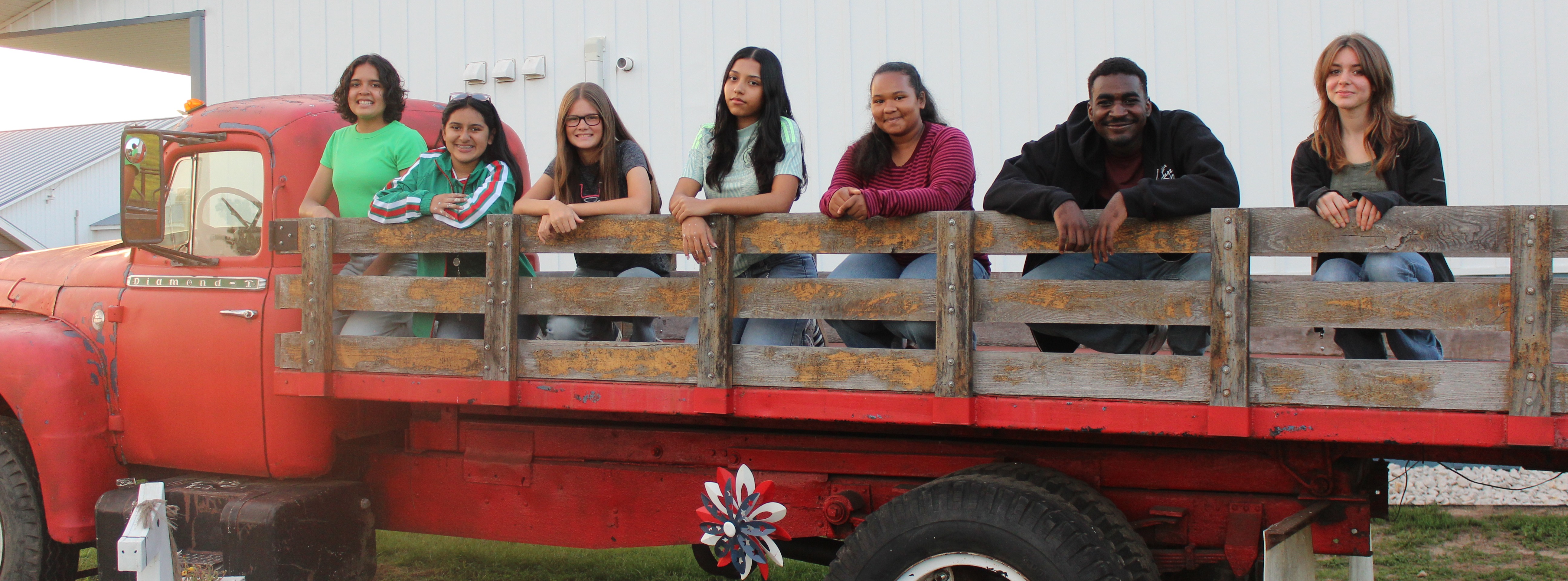 Teenagers posing on the back of an old pick up truck