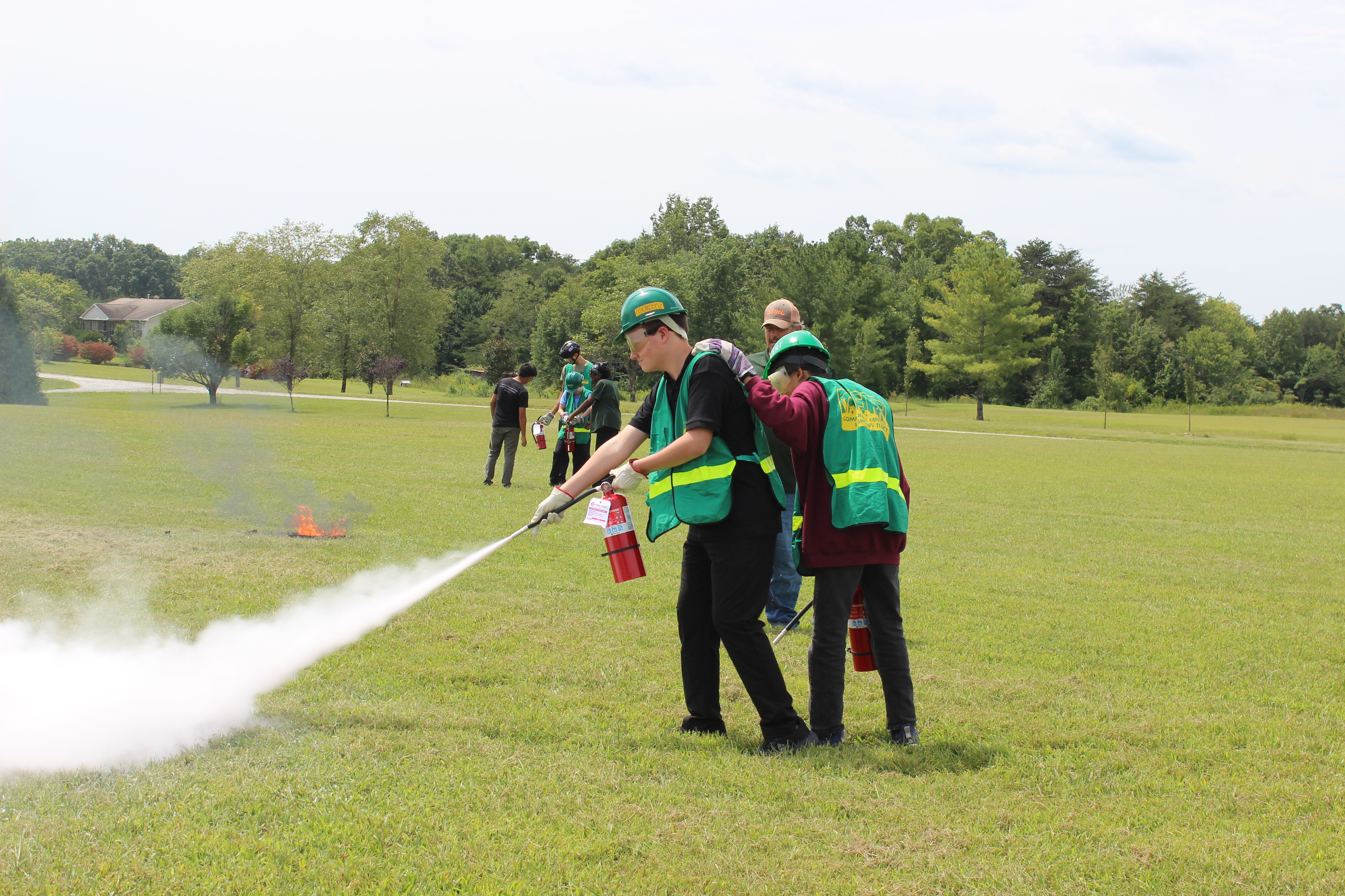 Teen boys learning to use a fire extinguisher