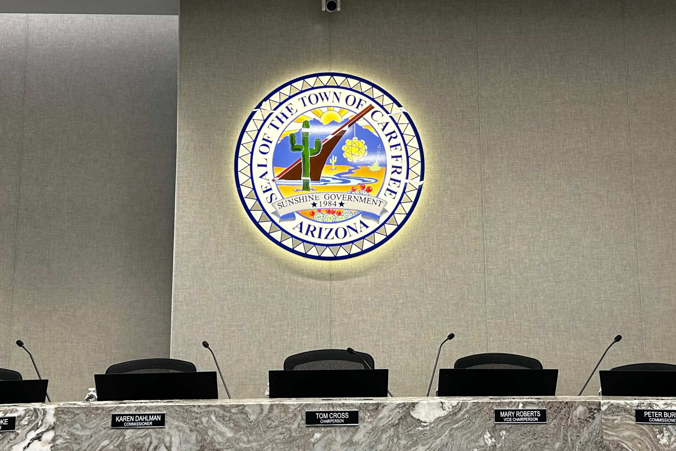Picture of the illuminated Town Seal above the dais in the Council Chambers.