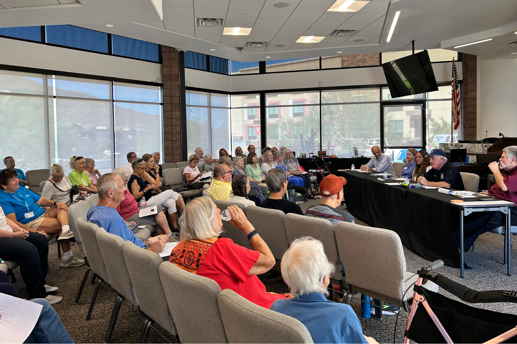 People sitting and watching a panel of speakers