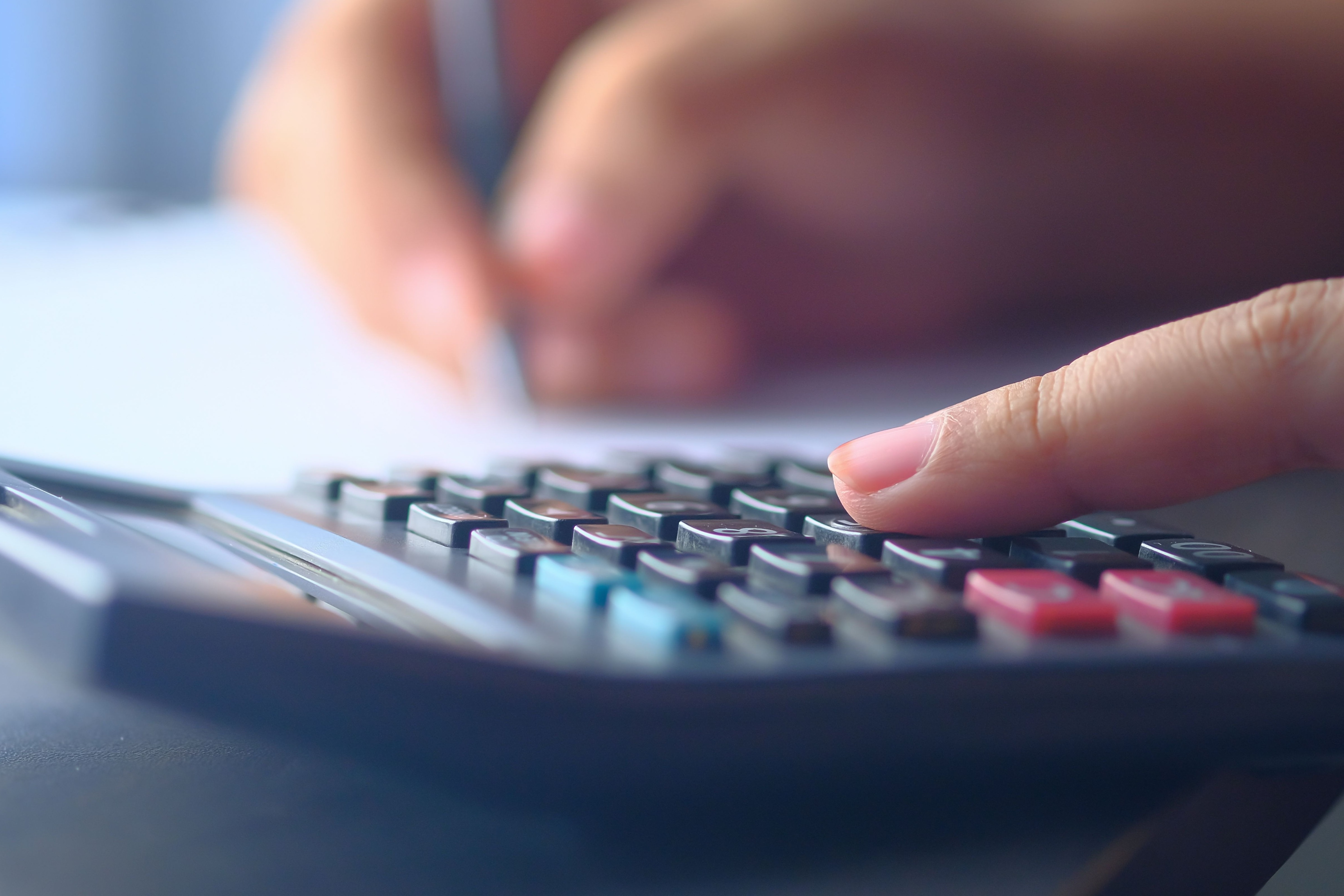 Someone using a calculator and a pen