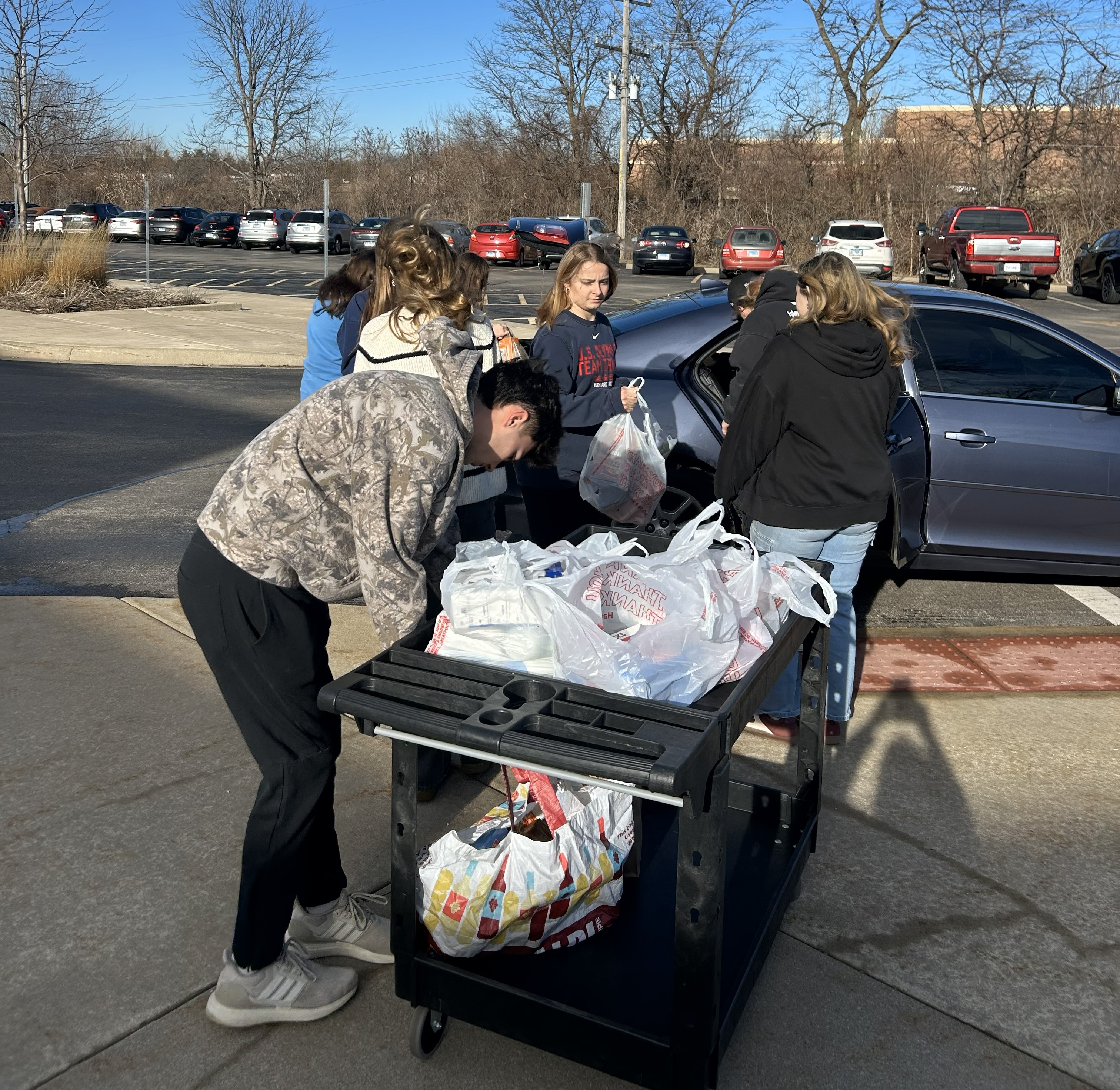 students pushing cart of donations
