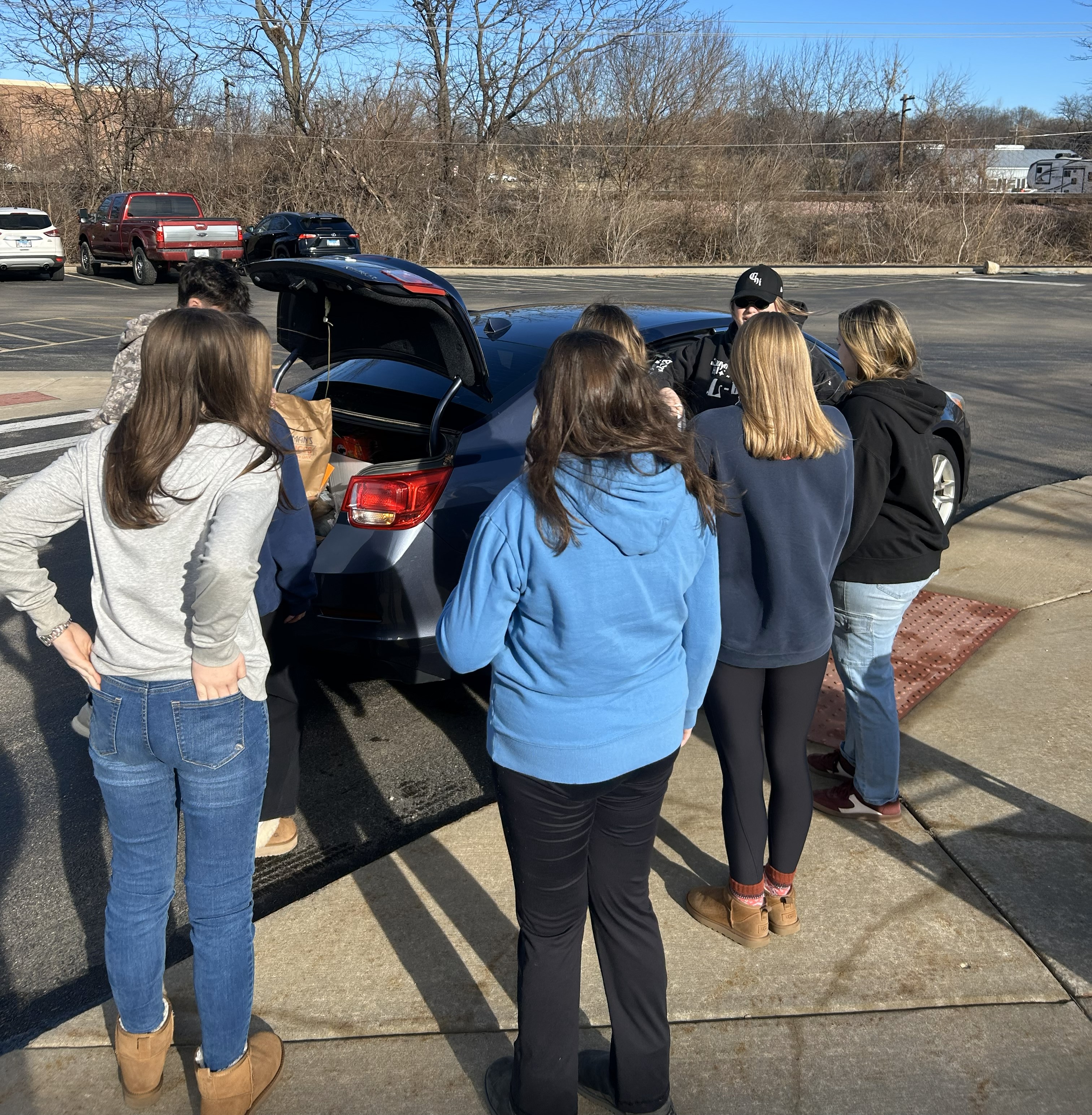 students unloading a car of donations