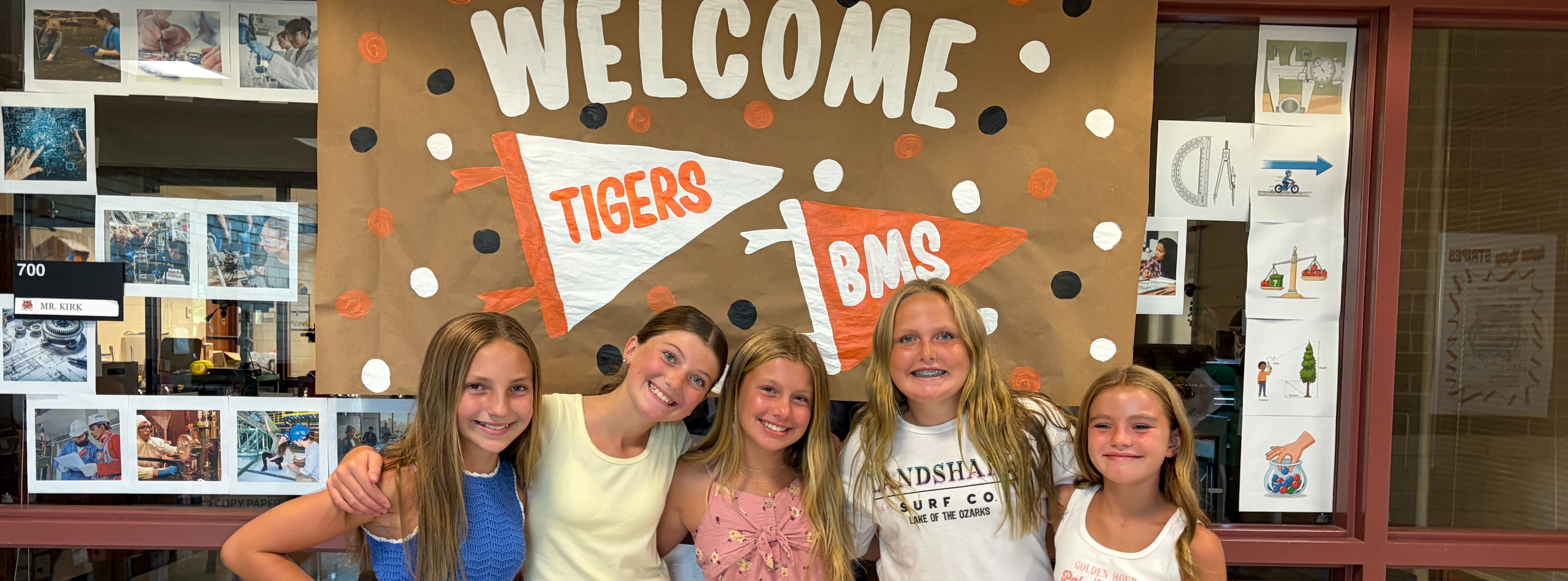 new 6th grade girls pose in front of a welcome sign at BMS