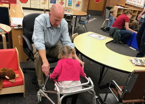 teacher helping out a student which is in a wheelchair 