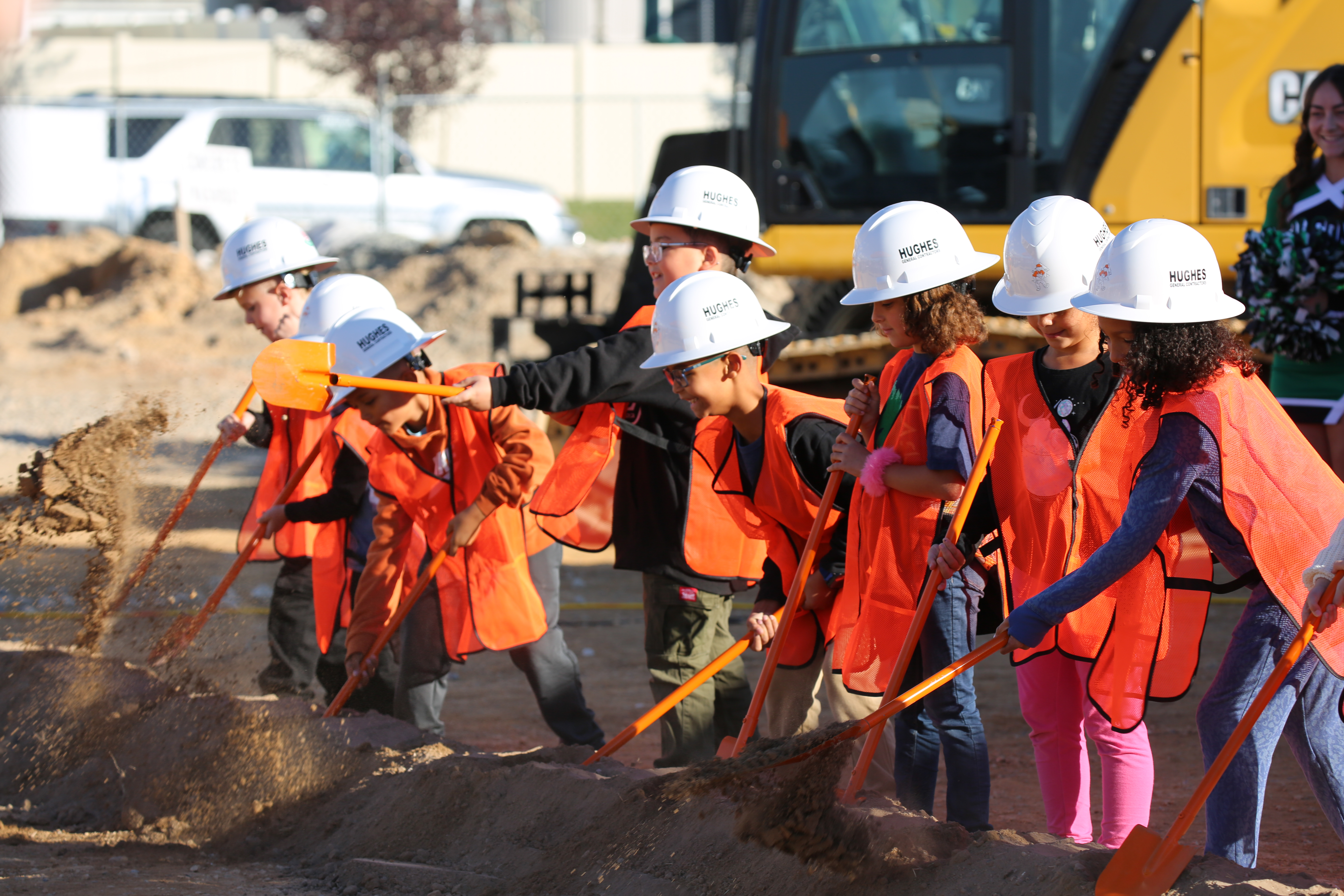 Future students shoveling dirt at the new elementary school groundbreaking.