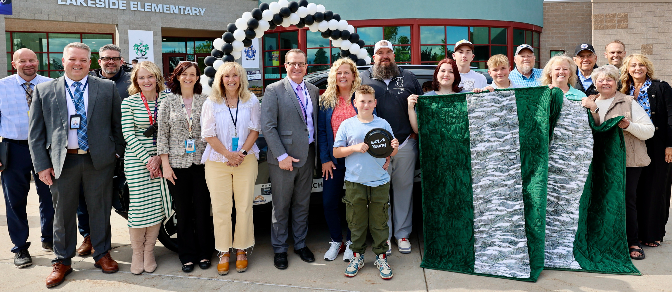 A photo of Hollie Fisher standing in front of her new car with Superintendency and Board Members. 