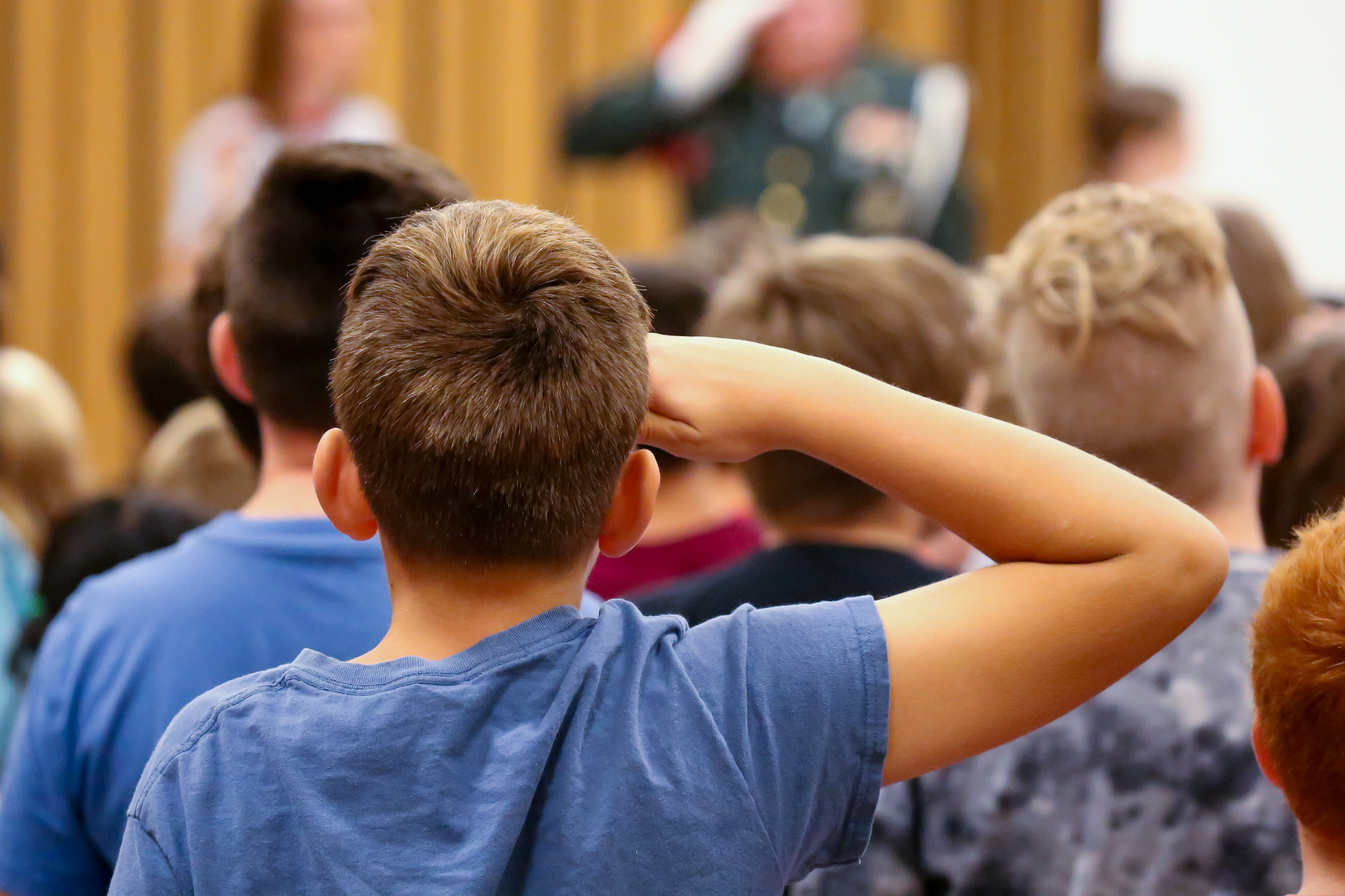 Student saluting from behind.