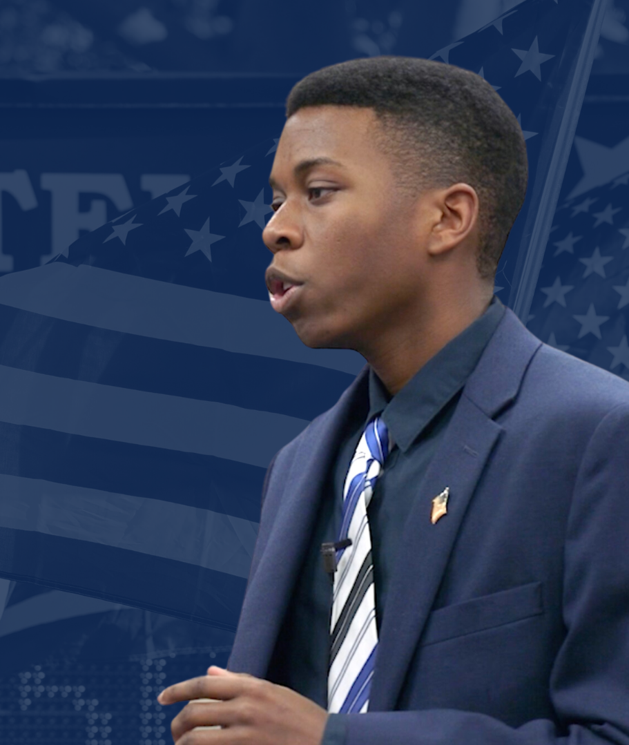 A studnet speaking with a flag background.
