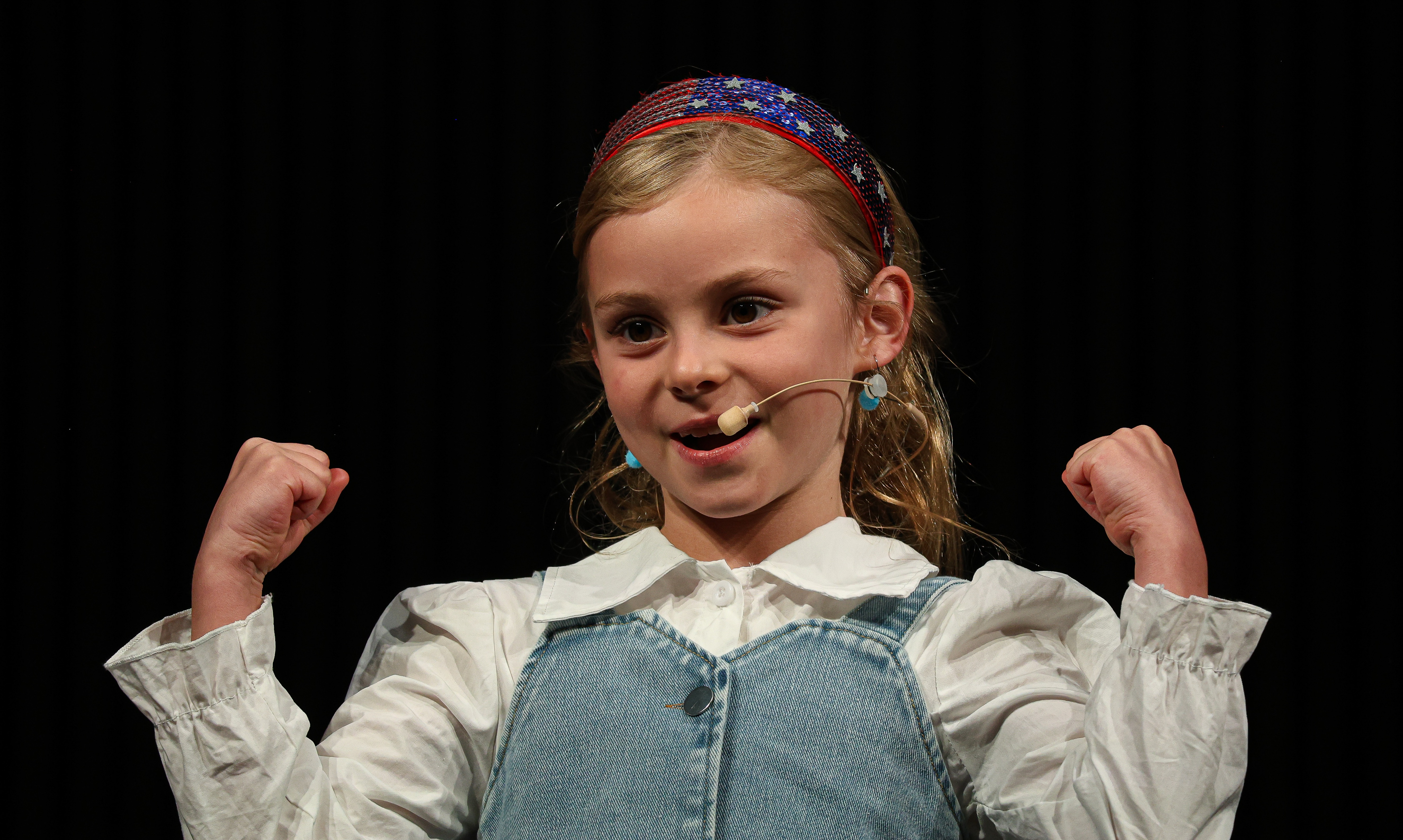 A student holding up her arms signifying she is strong.
