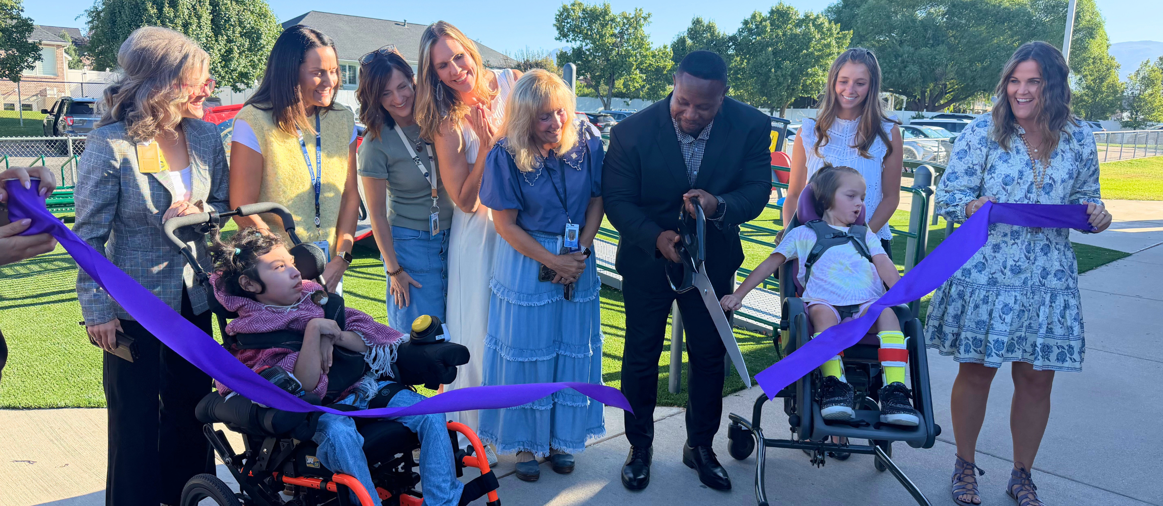 Board members and students cut the ribbon to celebrate the opening of the new all abilities playground at Bluff Ridge Elementary