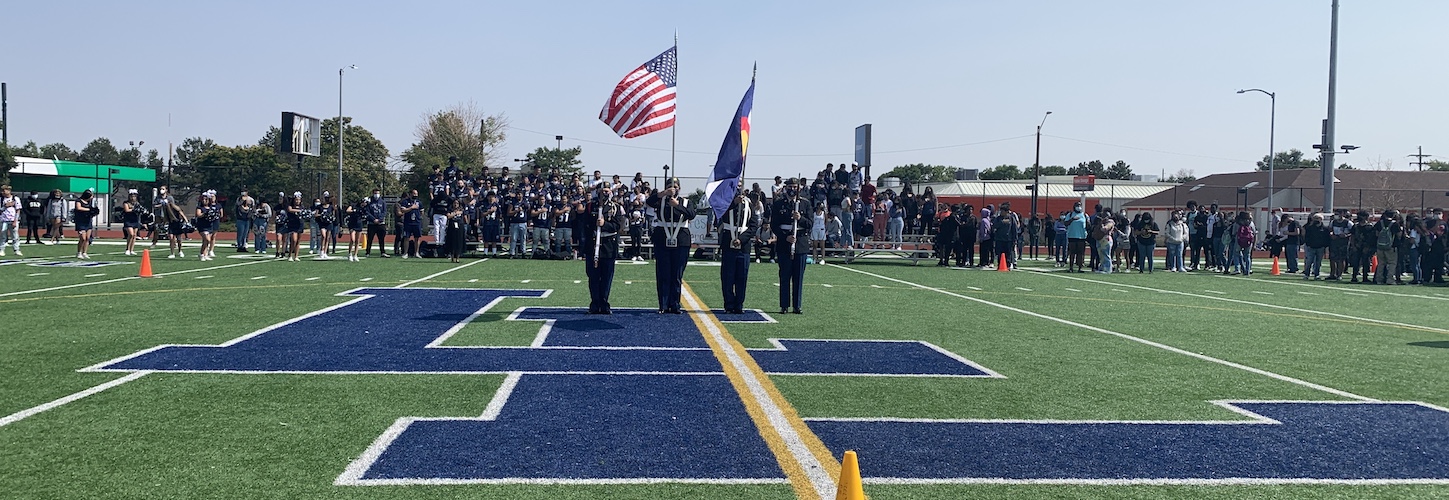 school football field with soldiers holding flags on it 