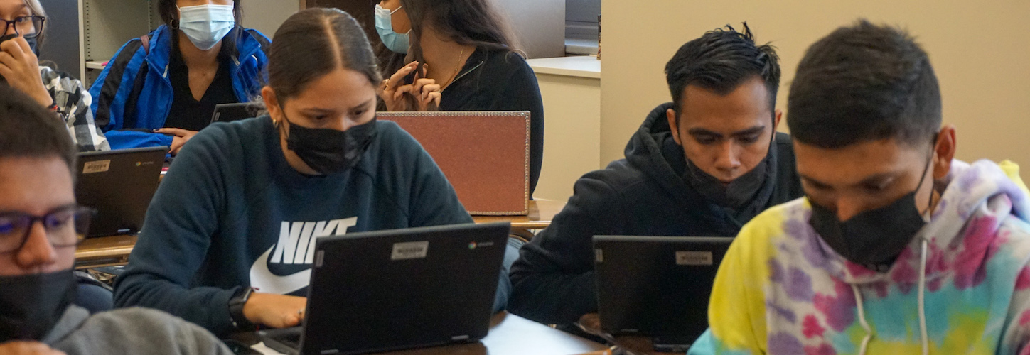 students sitting in classroom using their laptops 