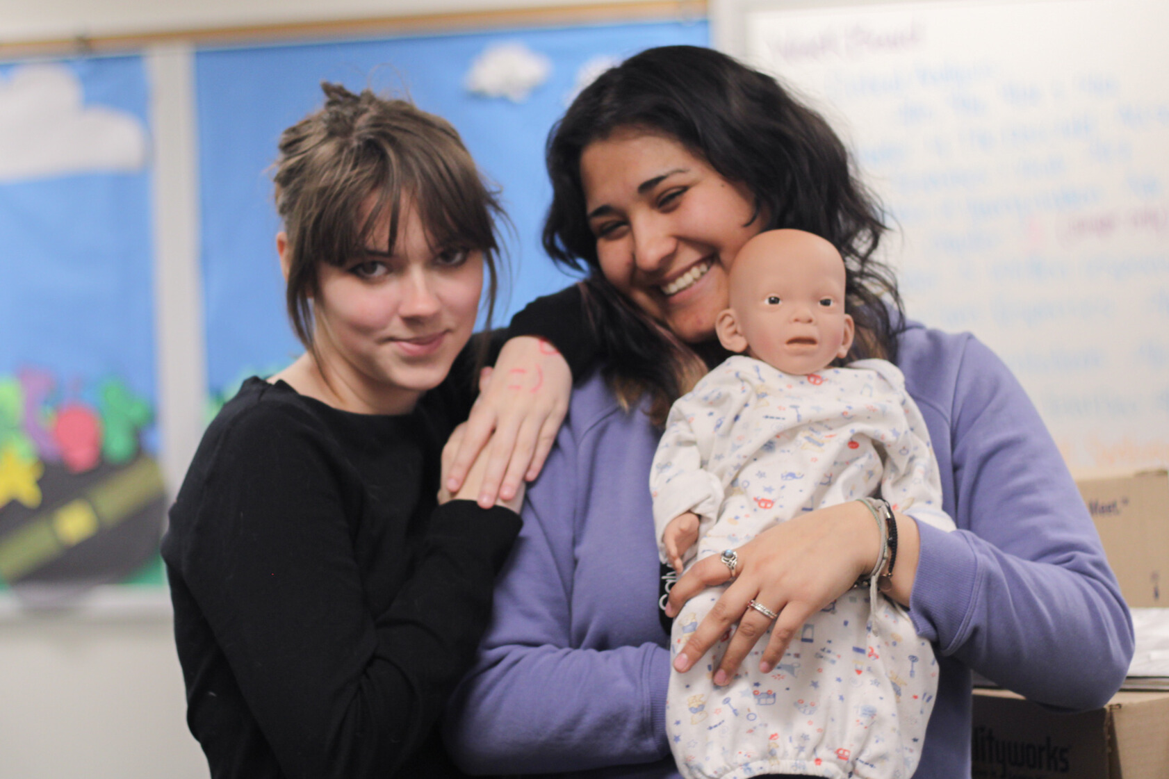 teachers hugging a baby