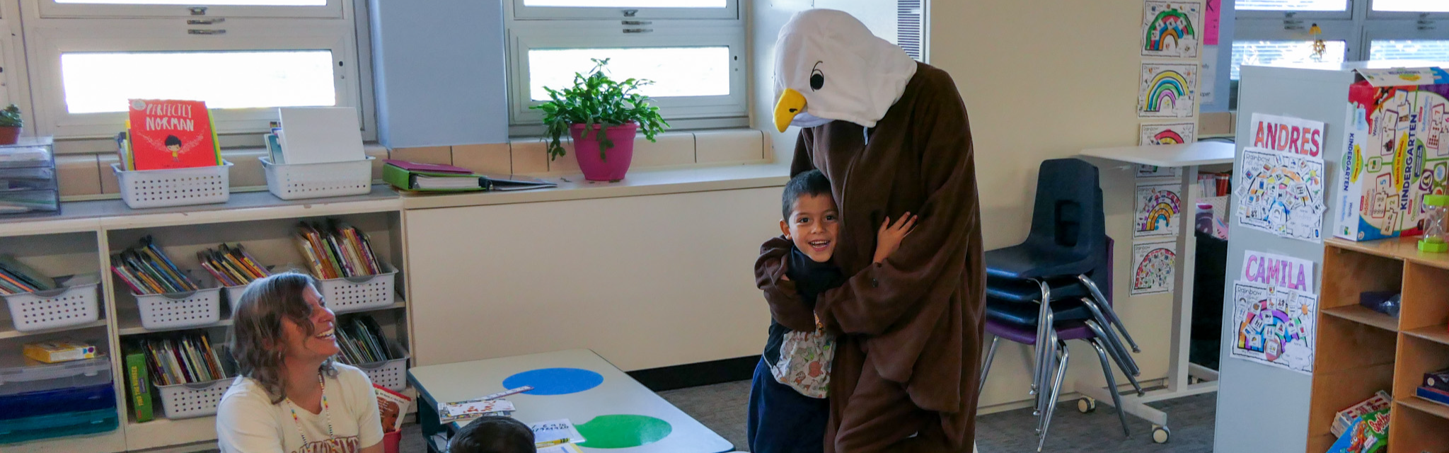 Ellie the Eagles hugs a student during an attendance celebration. 
