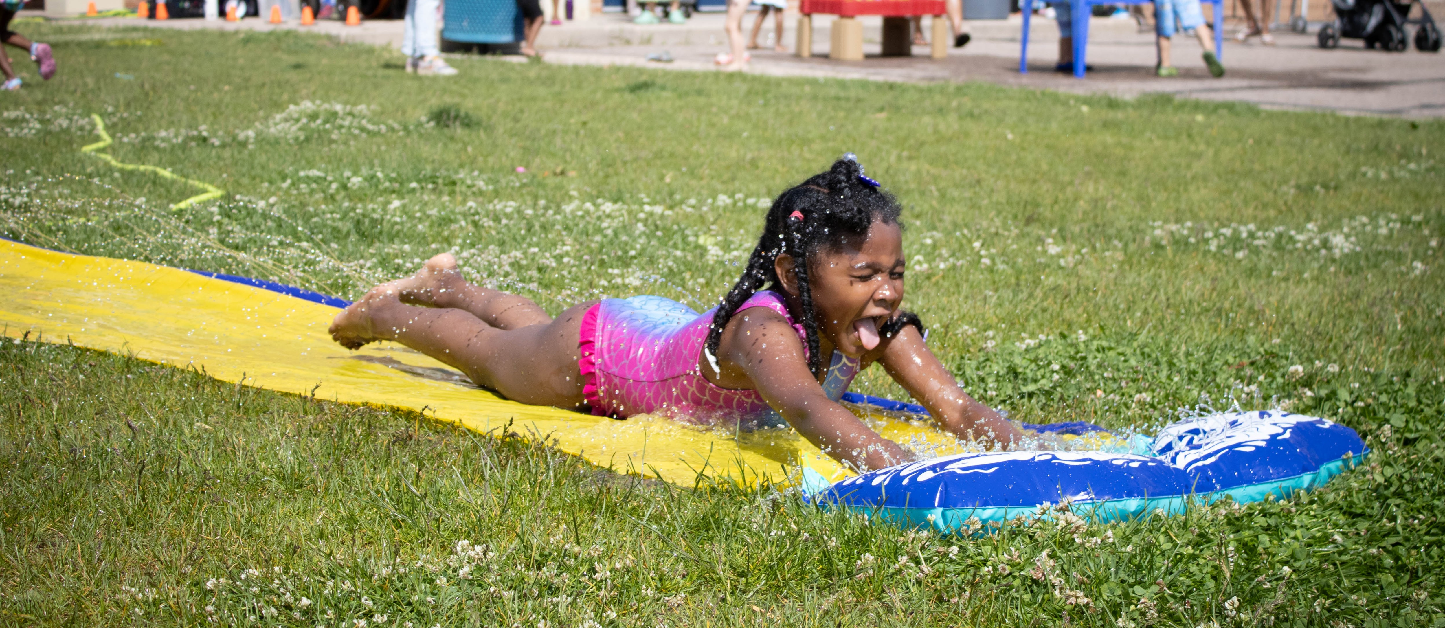 Hallett student laughing on the slip n slide