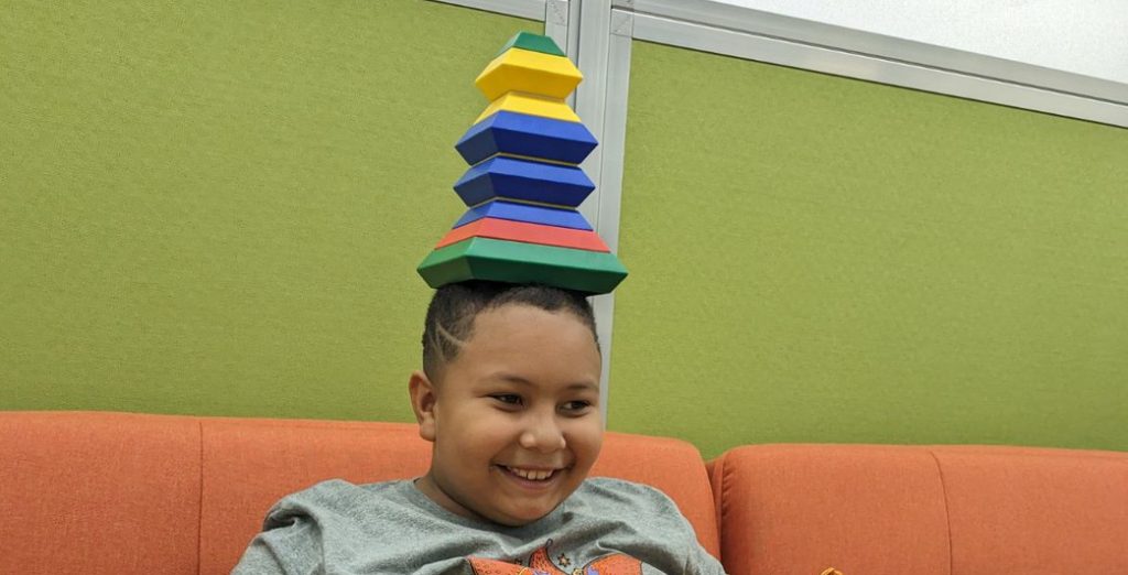 kid holding a game in their head