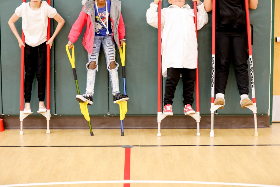 Four young individuals learning to play with red and yellow poles.