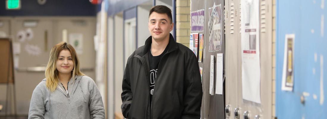 two people in the hallway looking at the camera