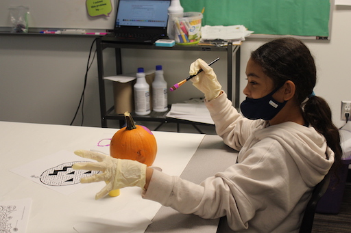 girl painting a pumpkin
