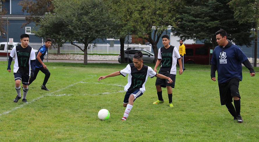 school soccer game , a boy kicking a ball