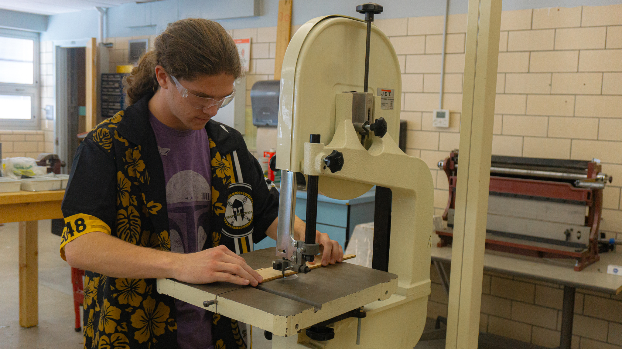 Image 2: Picture of a student using a saw on a piece of wood