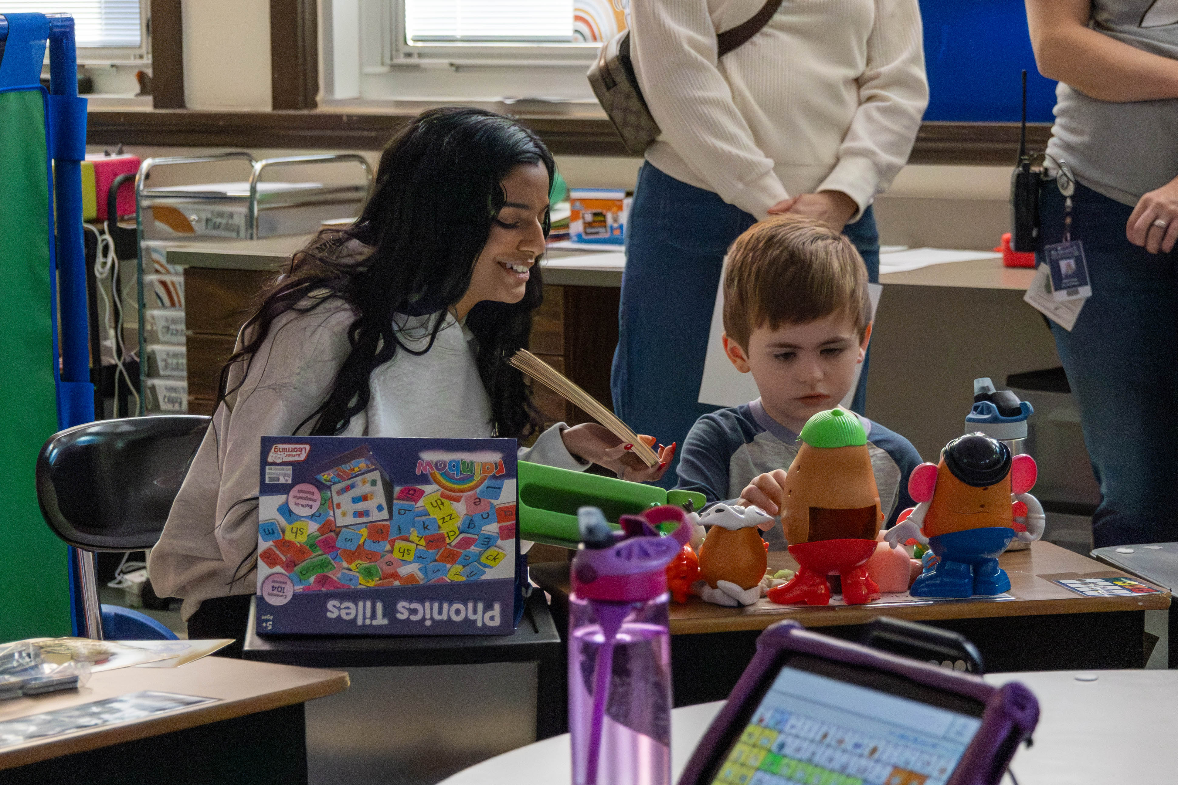 Picture of student and teacher learning phonics.  Mr. Potato Head in the foreground