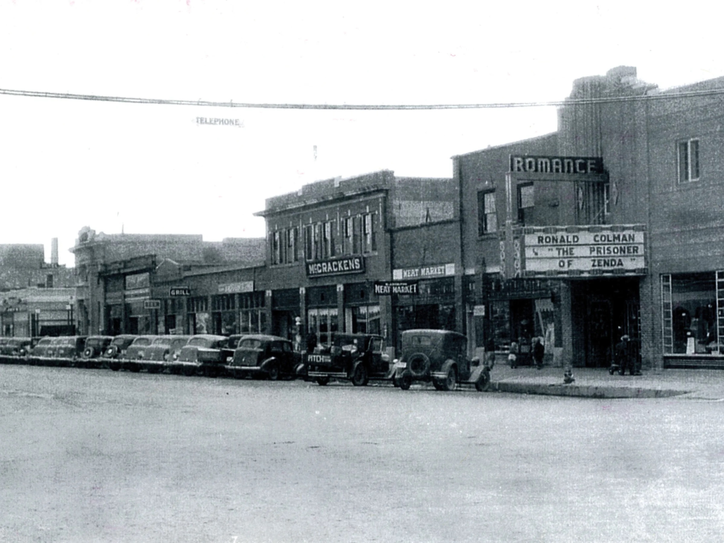 Old picture of a block with stores and a theatre