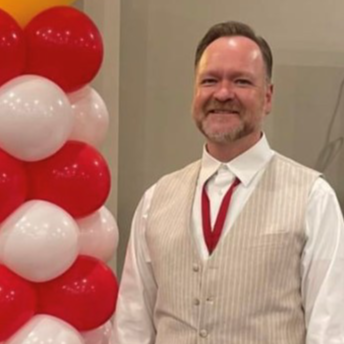 Portrait of Jed Platt next to balloon arch