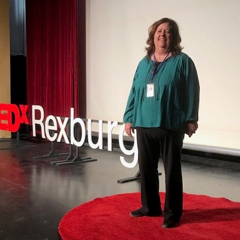 Donella on stage with TedX sign