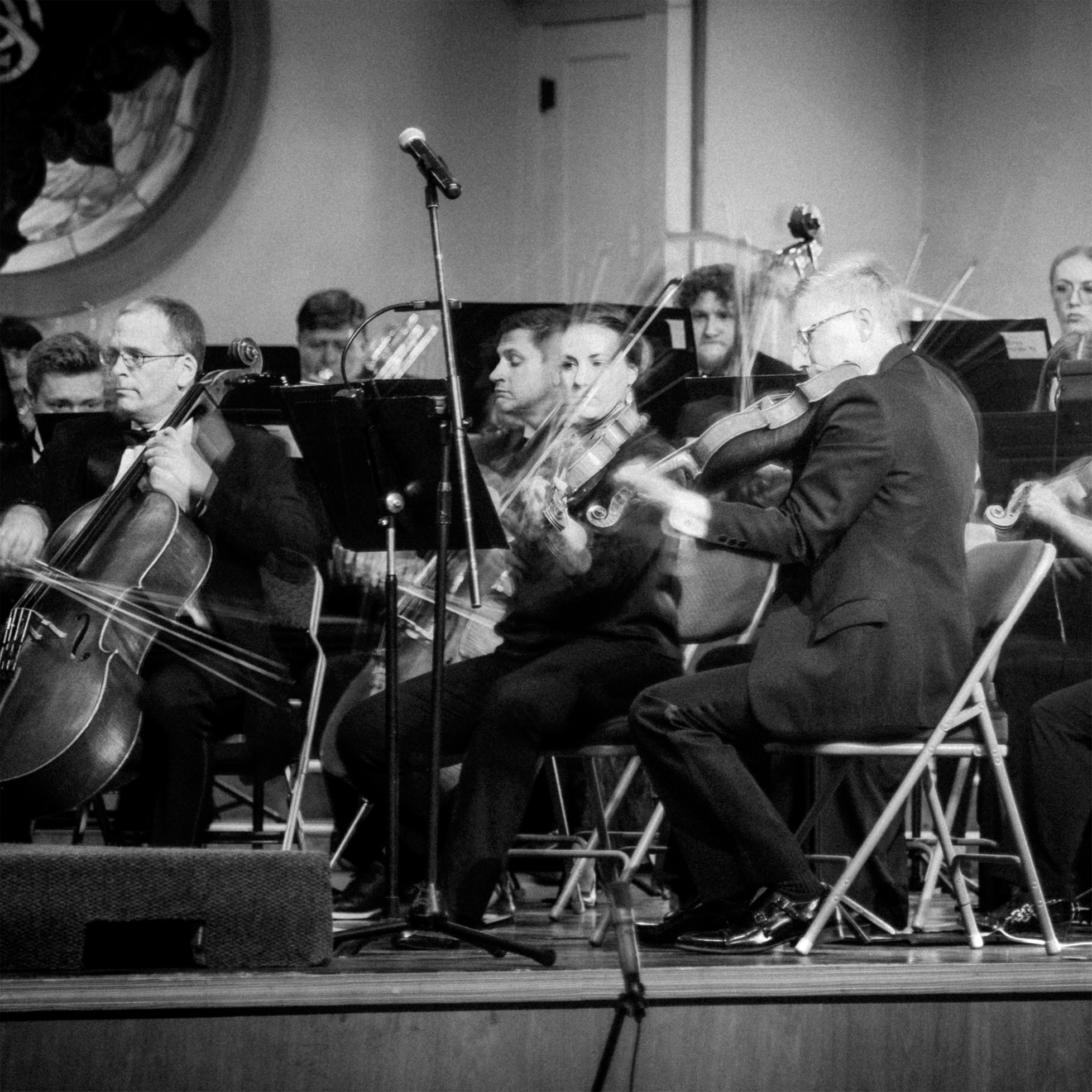 black and white photo of conductor in motion on stage at the Tabernacle