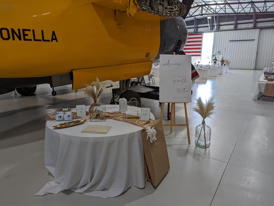 Event welcome table at the LFM with a yellow plane behind the table. 
