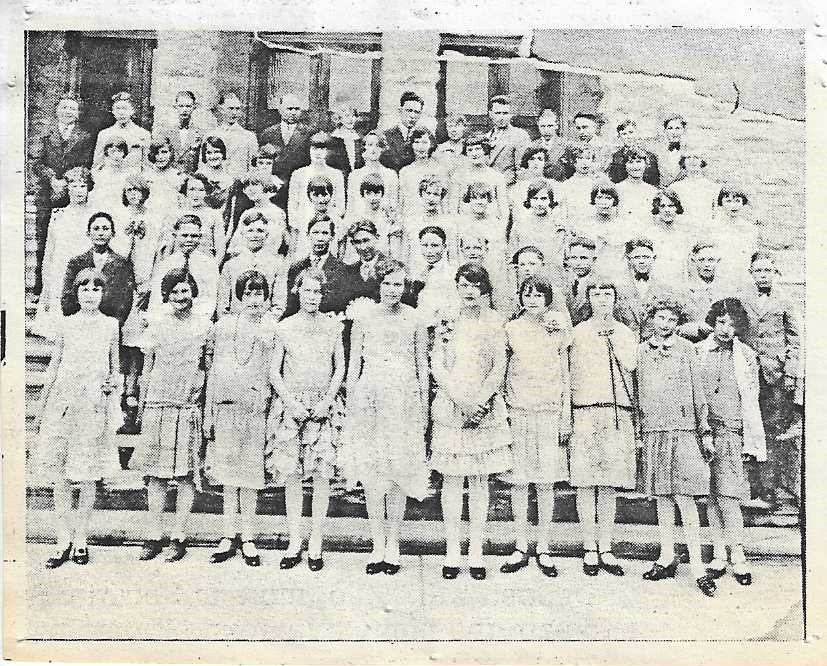 Old black & white photo of young women and men all dressed up on the steps of the Tabernacle. 