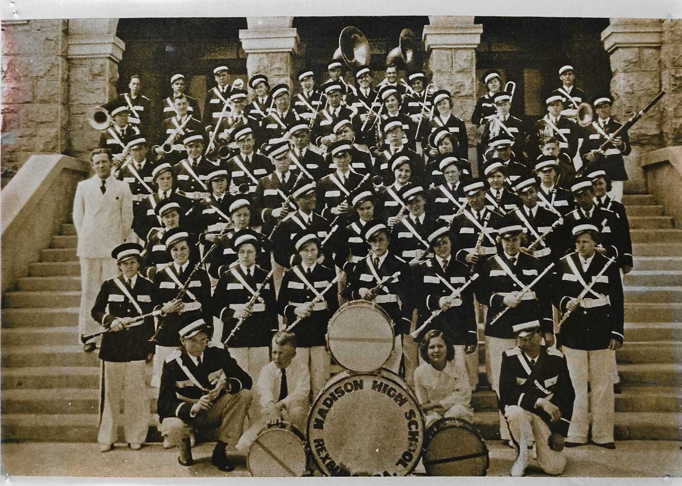 Old sepia photo of a Group of 50 some Madison High School Band members in band uniforms holding their instruments on the steps of the Tabernacle. 