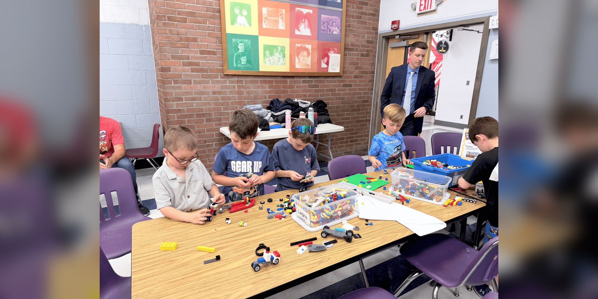 Children engaged in creative play with LEGO bricks at a table in a classroom, showcasing teamwork and imagination.