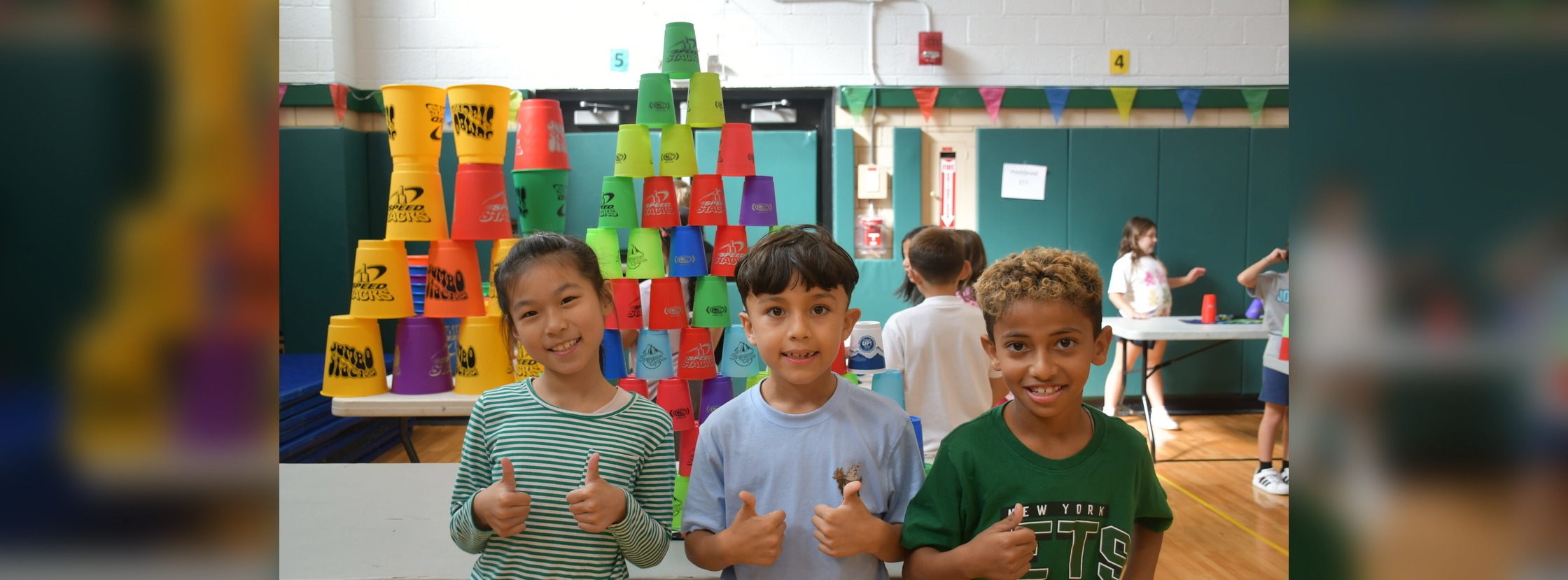 Students smiling in front of their projects.