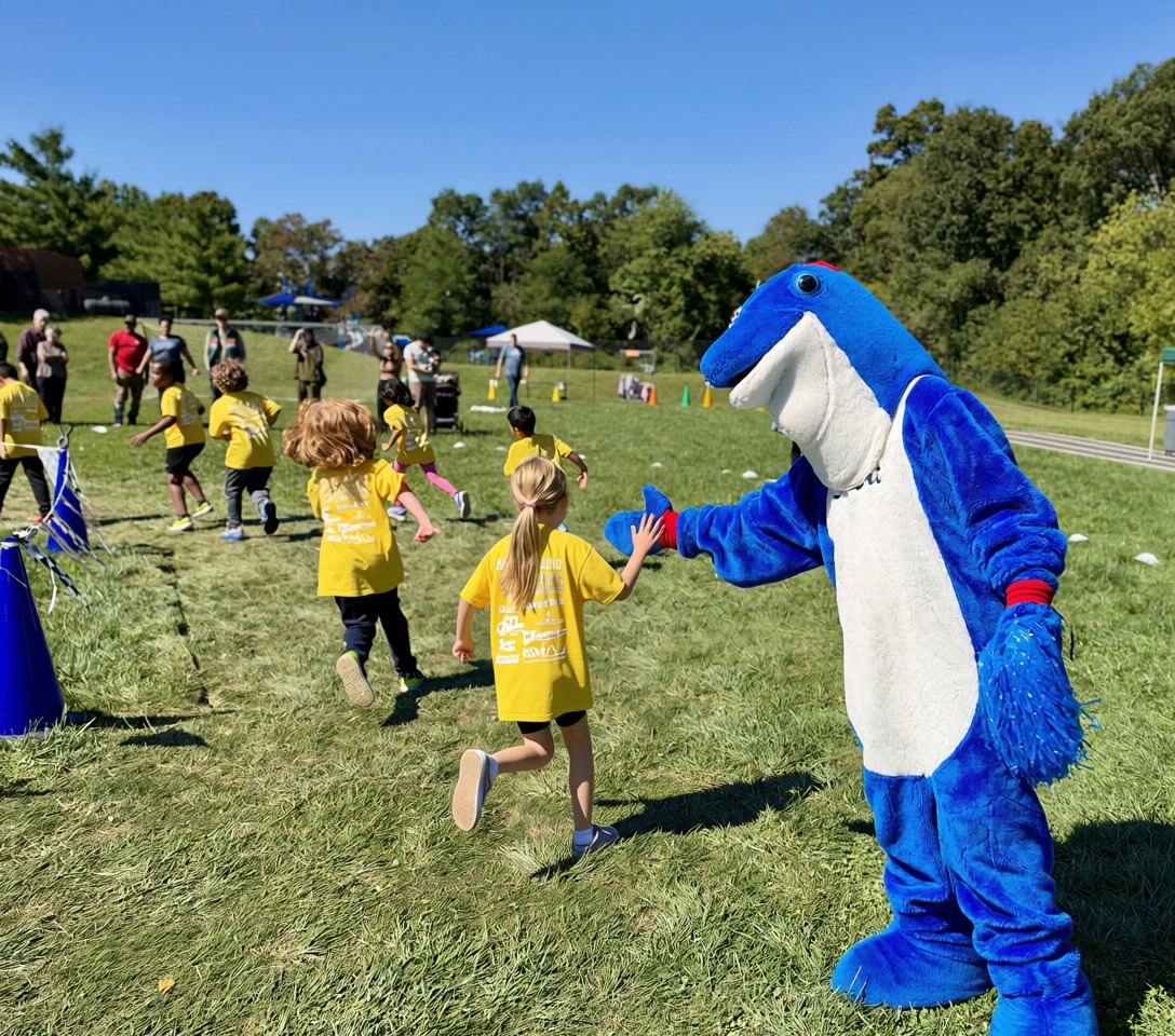 Dolphin mascot giving high-five to student